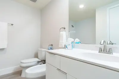 a white bathroom with a toilet and a sink at Golden Bay 402 in Miami Beach