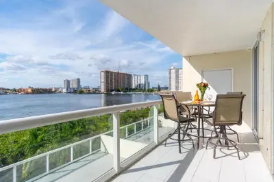 a balcony with a table and chairs overlooking the water at Golden Bay 402 in Miami Beach