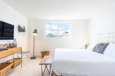 a white bedroom with a bed and a television at Ocean Reserve 1508 in Miami Beach