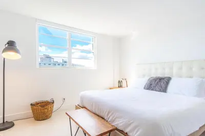 a white bedroom with a bed and a window at Ocean Reserve 1508 in Miami Beach