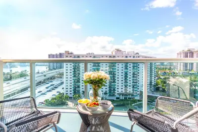 a balcony with two chairs and a table with flowers on it at Ocean Reserve 1508 in Miami Beach