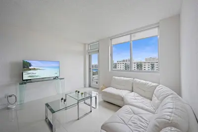 a living room with a white couch and a glass table at Ocean Reserve 1616 in Miami Beach