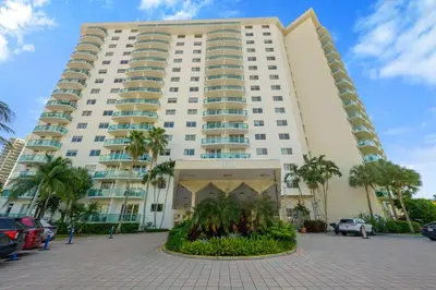 a large white building with palm trees in front of it at Ocean Reserve 1616 in Miami Beach