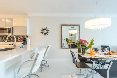 a kitchen with a table and chairs and a mirror at Marina Bay 1103 in Miami Beach