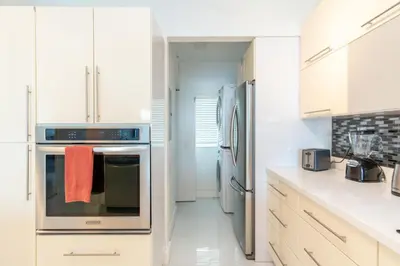 a kitchen with stainless steel appliances and white cabinets at Marina Bay 1103 in Miami Beach