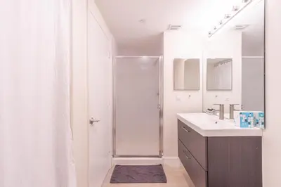 a white bathroom with a shower and a sink at Golden Bay 508 in Miami Beach