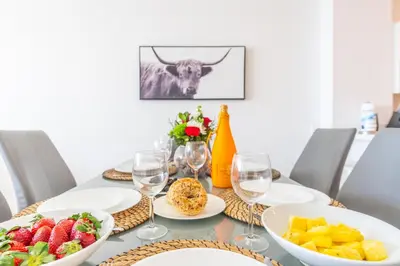 a dining table with plates of fruit and wine glasses at Golden Bay 606 in Miami Beach