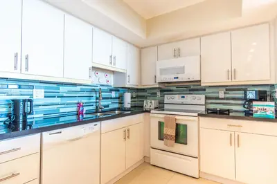 a white kitchen with white cabinets and appliances at Ocean Reserve PH1 in Miami Beach