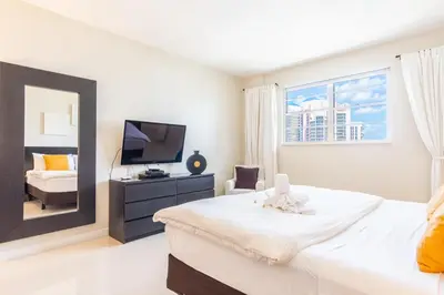 a bedroom with a large bed and a mirror at Ocean Reserve PH1 in Miami Beach