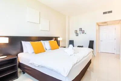a bedroom with a large bed with orange and white pillows at Ocean Reserve PH1 in Miami Beach