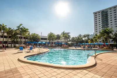 a swimming pool in a resort with palm trees and buildings at Ocean Reserve PH1 in Miami Beach