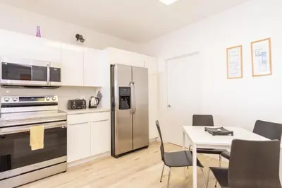 a kitchen with a refrigerator and a table with chairs at Golden Bay 1003 in Miami Beach