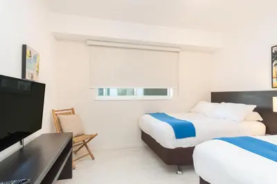 a hotel room with two beds and a flat screen tv at Golden Bay 1003 in Miami Beach