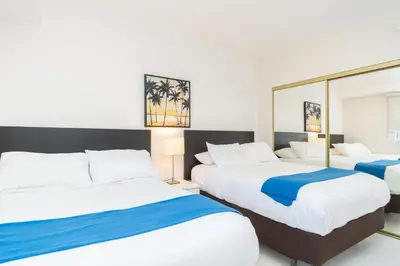 a hotel room with two beds and a mirror at Golden Bay 1003 in Miami Beach