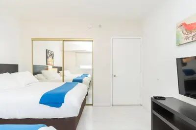 a bedroom with two beds and a flat screen tv at Golden Bay 1003 in Miami Beach