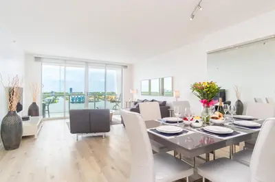 a dining room and living room with a table and chairs at Golden Bay 1003 in Miami Beach