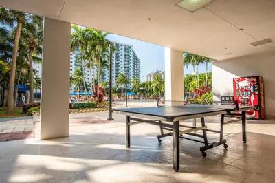 a ping pong table in a building with palm trees at Ocean Reserve 818 in Miami Beach