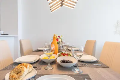 a dining table with plates and glasses of wine at Golden Bay 502 in Miami Beach