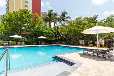 a swimming pool with chairs and umbrellas at a hotel at Golden Bay 509 in Miami Beach