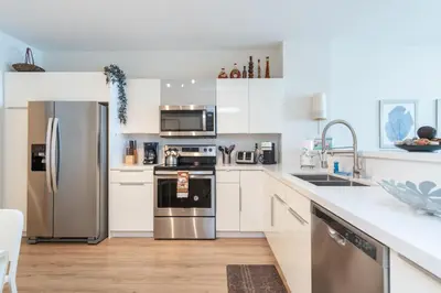 a kitchen with white cabinets and stainless steel appliances at Golden Bay 602 in Miami Beach