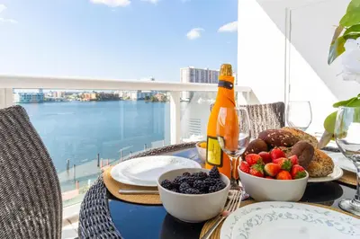 a table with a plate of food and a bottle of wine at Golden Bay 602 in Miami Beach