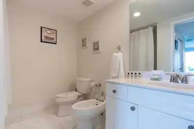 a white bathroom with a toilet and a sink at Golden Bay 302 in Miami Beach