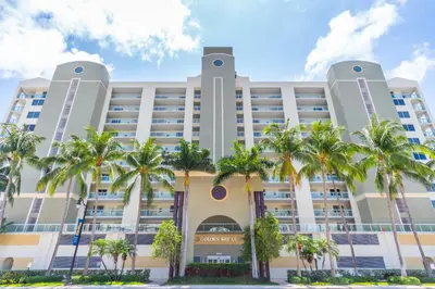 a building with palm trees in front of it at Golden Bay 302 in Miami Beach