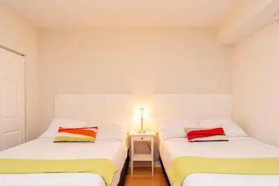 two beds in a room with a table and a lamp at Golden Bay 707 in Miami Beach