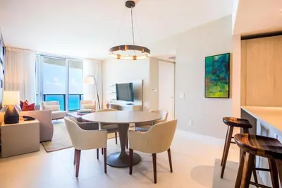 a dining room and living room with a table and chairs at Lyfe Beach Resort 3604 in Hollywood Beach