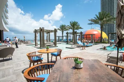 a patio with a table and chairs and a pool at Lyfe Beach Resort 3604 in Hollywood Beach