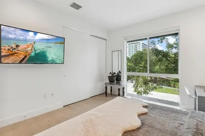 a white living room with a large tv on the wall at City Forest One,Brand New Living, Executive /1Gb/s in Miami