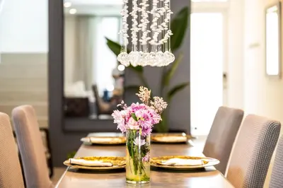 a dining room table with a vase of pink flowers at City Forest One,Brand New Living, Executive /1Gb/s in Miami