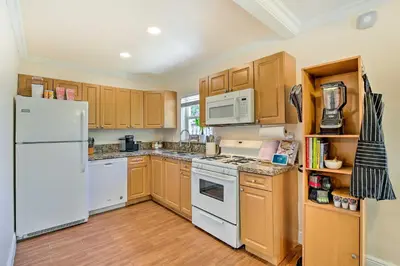 a kitchen with white appliances and wooden cabinets at Vacation Rental with Private Pool in Wilton Manors in Fort Lauderdale