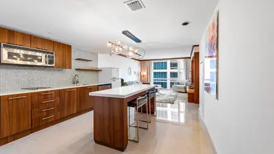 a kitchen with wooden cabinets and a white counter top at 1 Bedroom Private Residence at Carillon Miami Resort -911 in Miami Beach