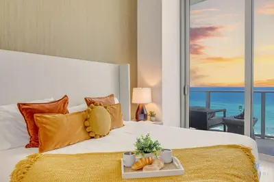 a bedroom with a bed with a view of the ocean at Beachfront Condo Front Oceanview Balcony Pools in Hollywood