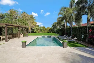 a swimming pool in a yard with chairs and trees at Luxury home w pool by PMI in Miami