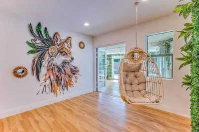 a room with a swinging chair in a house at Fox Garden-Heated Pool-Spa- Boho-Downtown & Beach in Fort Lauderdale