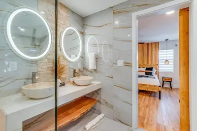 a bathroom with two sinks and a large mirror at Fox Garden-Heated Pool-Spa- Boho-Downtown & Beach in Fort Lauderdale