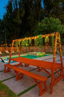 a wooden bench in front of a pool with lights at Fox Garden-Heated Pool-Spa- Boho-Downtown & Beach in Fort Lauderdale