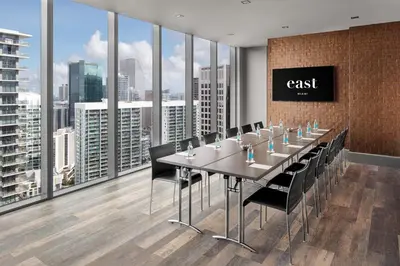 a conference room with a long table and black chairs at EAST Miami Residences in Miami