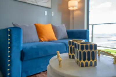 a living room with a blue couch and a table at Devereaux Miami 2 Bedroom, 1 Bedroom, and Studio Condos with Balconies in Miami