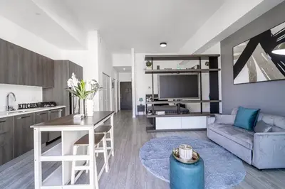 a kitchen and living room with a couch and a tv at Devereaux Miami 2 Bedroom, 1 Bedroom, and Studio Condos with Balconies in Miami