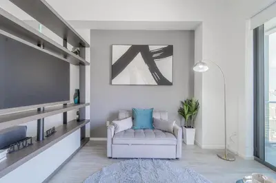a living room with a couch and a tv at Devereaux Miami 2 Bedroom, 1 Bedroom, and Studio Condos with Balconies in Miami