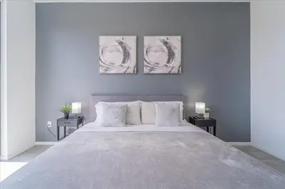 a bedroom with a large bed with three paintings on the wall at Devereaux Miami 2 Bedroom, 1 Bedroom, and Studio Condos with Balconies in Miami