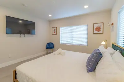 a bedroom with a large white bed and a television at Mega Fun Villa Northwest Miami BY THE GLAMHOMES in Miami