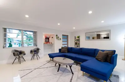 a living room with a blue couch and a table at Cool Villa Northwest Miami BY THE GLAMHOMES in Miami