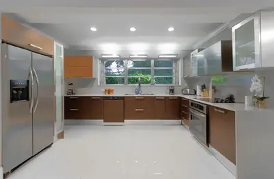 a large kitchen with wooden cabinets and stainless steel appliances at Cool Villa Northwest Miami BY THE GLAMHOMES in Miami