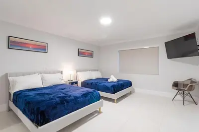 a bedroom with two beds and a flat screen tv at Cool Villa Northwest Miami BY THE GLAMHOMES in Miami
