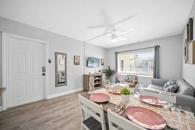 a dining room and living room with a table and chairs at The Leeward Apartments By Lowkl in Fort Lauderdale