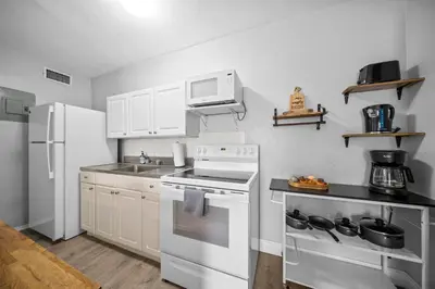 a kitchen with white appliances and a white refrigerator at The Leeward Apartments By Lowkl in Fort Lauderdale